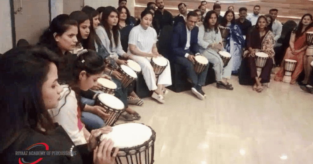 Corporate Team Building Activities in Pune: How Rhythm and Music Can Transform Workplace Teams 5 Corporate employees participating in a Djembe drumming session during corporate team building activities in Pune